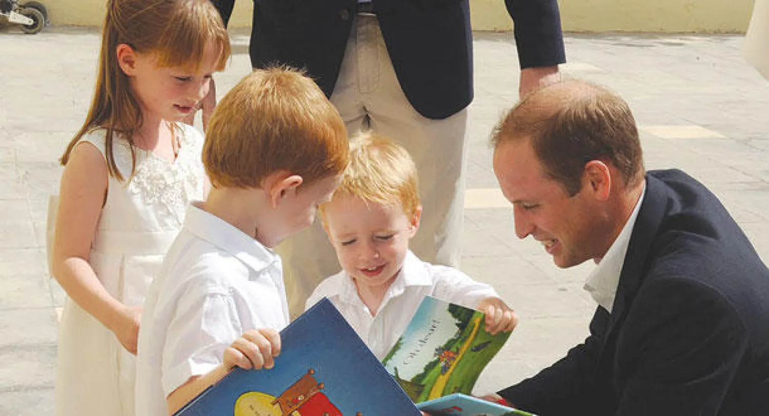 الأمير ويليام دوق كمبردج يداعب أطفالا بريطانيين في قنصلية بلاده في العاصمة فاليتا أمس (إ.ب.أ)