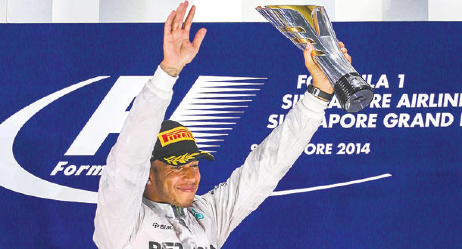هاميلتون على منصة التتويج في سنغافورة أمس (رويترز)
