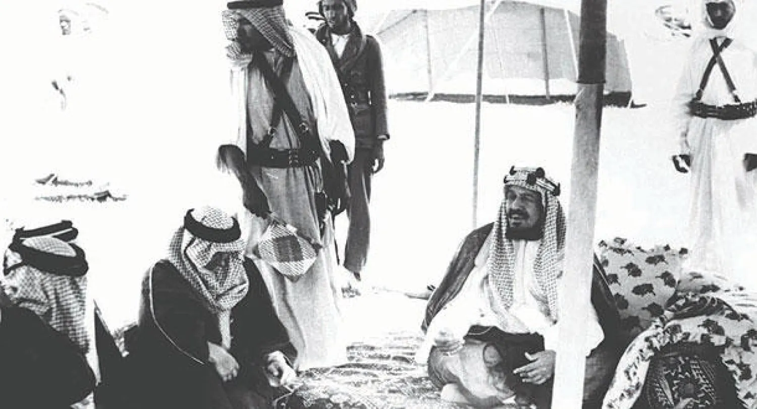 الملك المؤسس مستقبلاً عدداً من المسؤولين الأميركيين في شركة أرامكو بأحد مخيمات الملك قرب وادي الرمة