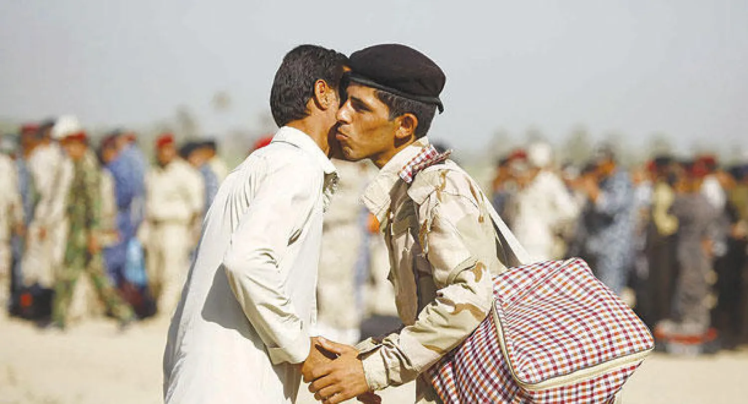 عنصر ميليشيا يودع أحد أقاربه في الحيرة جنوب النجف قبل توجهه إلى جبهات القتال ضد «داعش» أمس (أ.ف.ب)