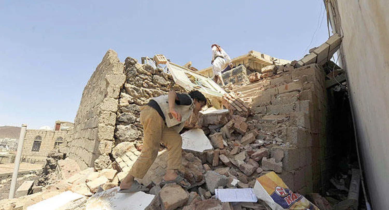 يمنيان يعاينان الدمار الذي لحق بمنازليهما جراء المعارك الأخيرة بين قوات الجيش اليمني وجماعة الحوثيين في صنعاء أمس  (إ.ب.أ)