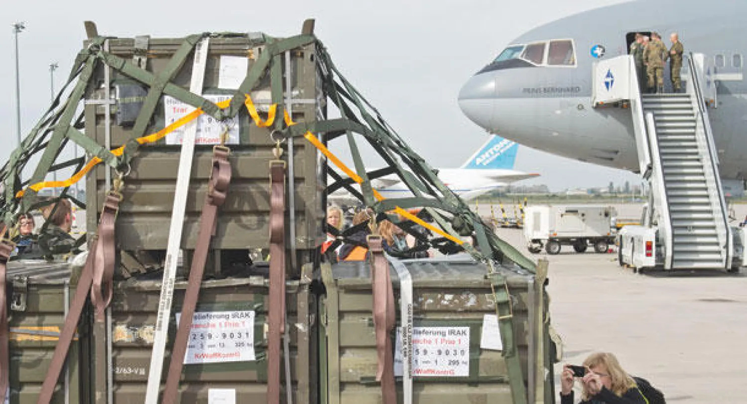 صحافي يلتقط صورا لحاويات بداخلها معدات عسكرية قبل تحميلها في طائرة تابعة لسلاح الجو الهولندي في لايبزغ بوسط ألمانيا لتنقلها إلى العراق أمس (أ.ب)
