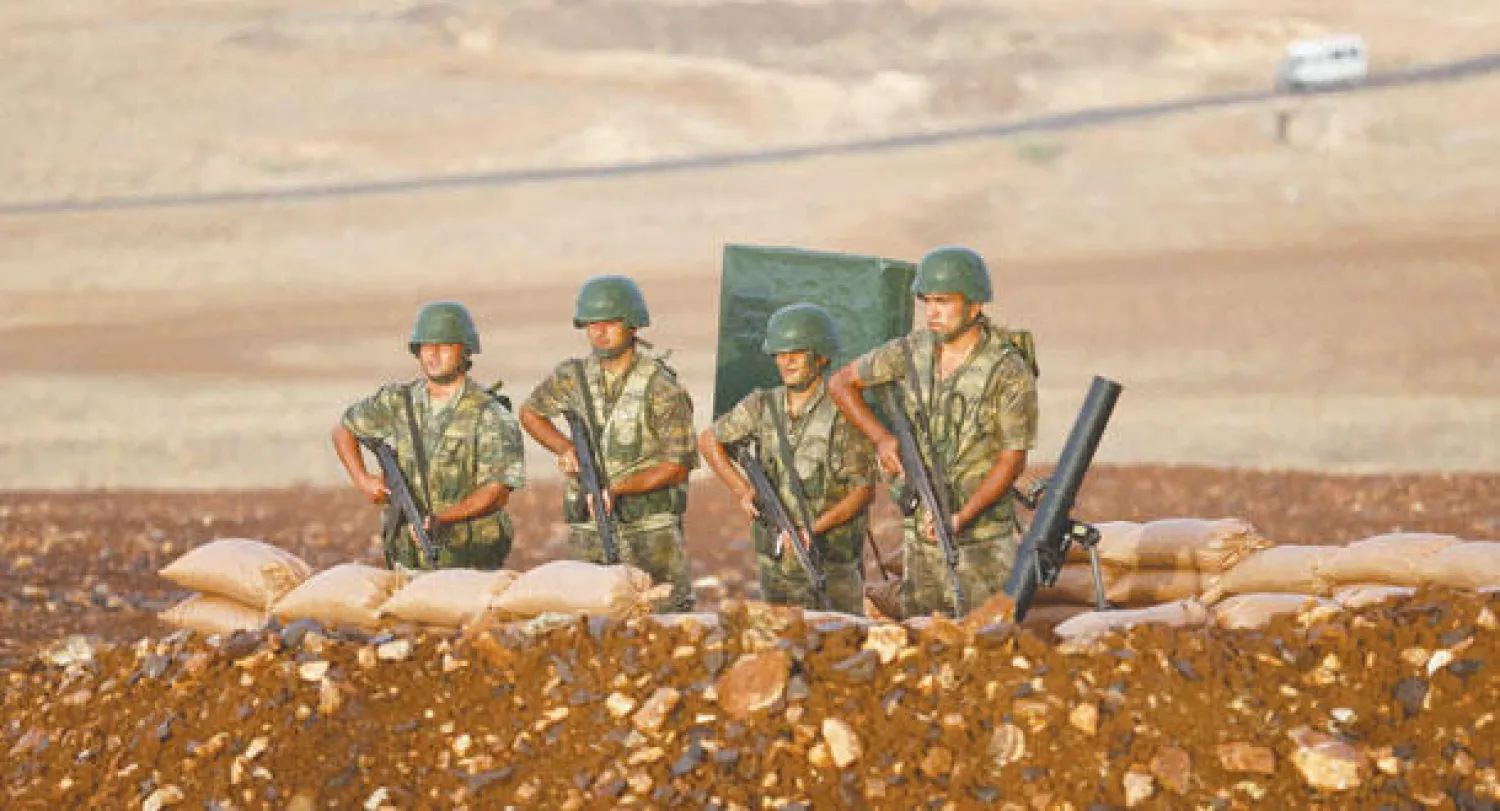 جنود أتراك على أهبة الاستعداد قرب الحدود السورية أمس (رويترز)