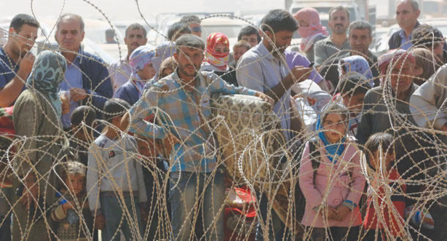 لاجئون سوريون نزحوا من كوباني ينتظرون دخول الأراضي التركية أمس (أ.ب)