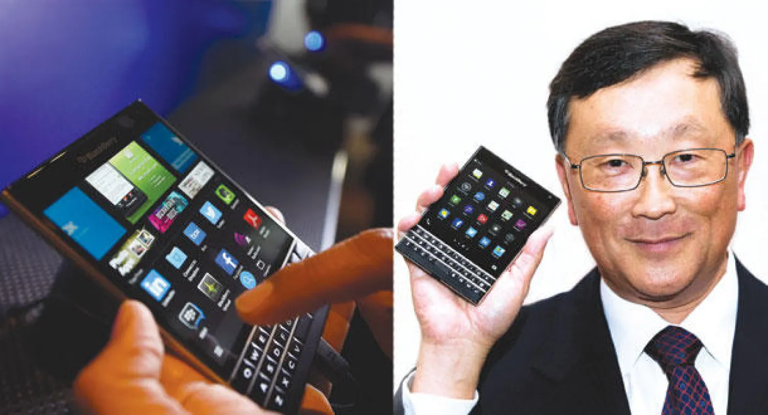 جون تشن الرئيس التنفيذي لشركة بلاكبيري  -  فرد من الجمهور يتفحص هاتف بلاكبيري باسبورت في حفل تدشينه بمدينة تورونتو الكندية (رويترز)