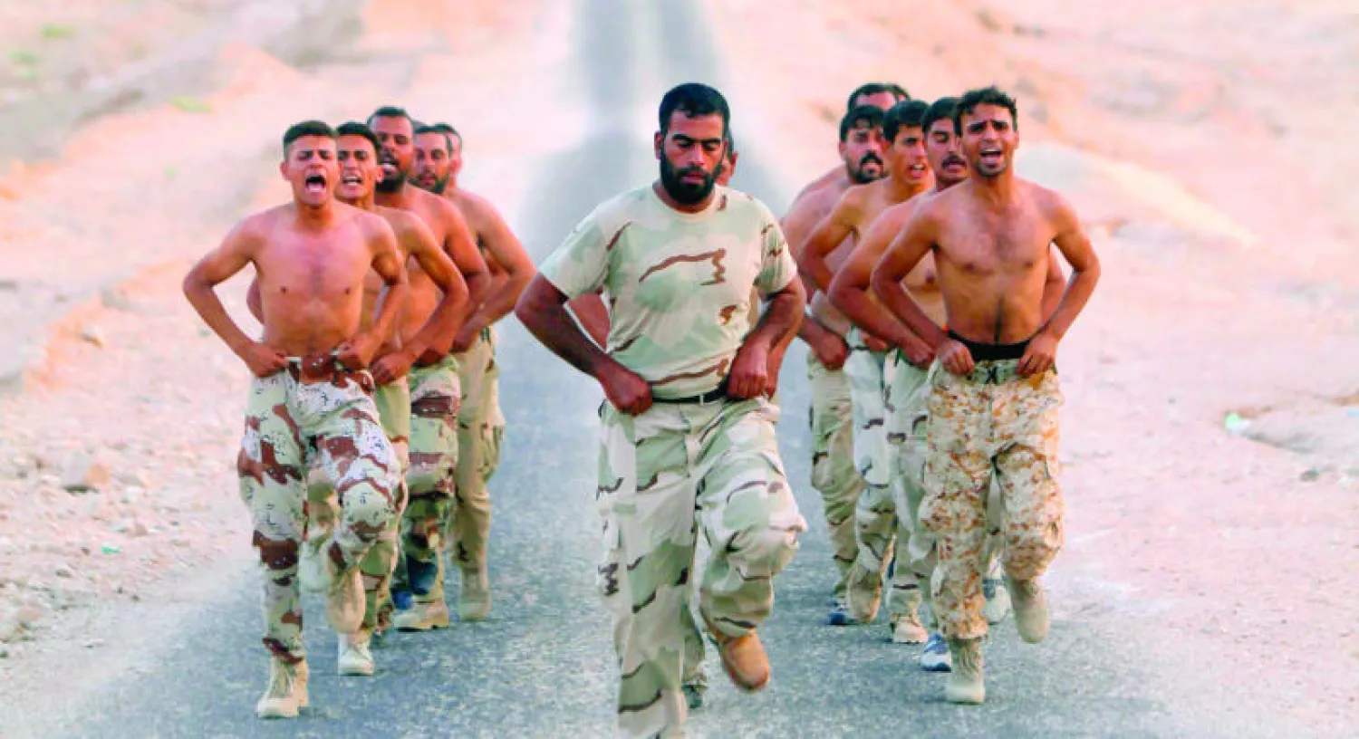متطوعون انضموا إلى الجيش العراقي يتدربون في منطقة صحراوية بين كربلاء والنجف جنوب بغداد أمس (رويترز)