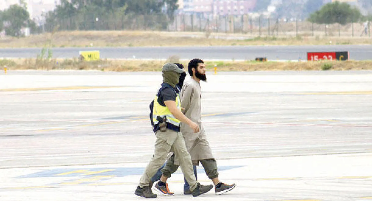 عنصران من الشرطة الاسبانية لدى اعتقالهما أحد أفراد خلية يشتبه بعلاقتها بتنظيم {داعش} أمس (إ.ب.أ)