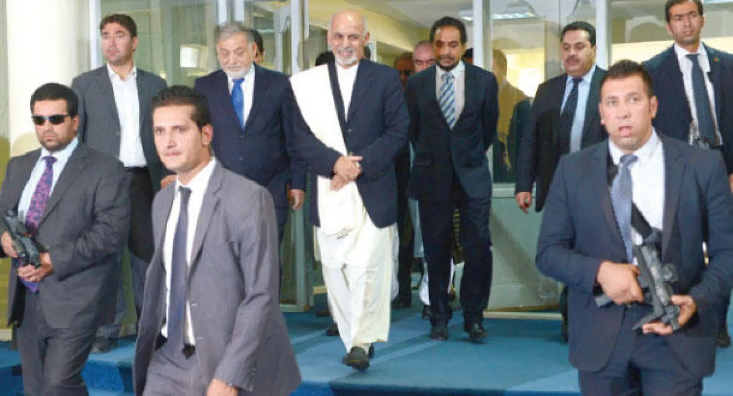 غني (وسط) أثناء وصوله رفقة حراسه الشخصيين إلى اجتماع عقدته اللجنة المستقلة للانتخابات وكشفت فيه النتائج الرسمية للاقتراع الرئاسي في كابل أمس (ا.ف.ب)