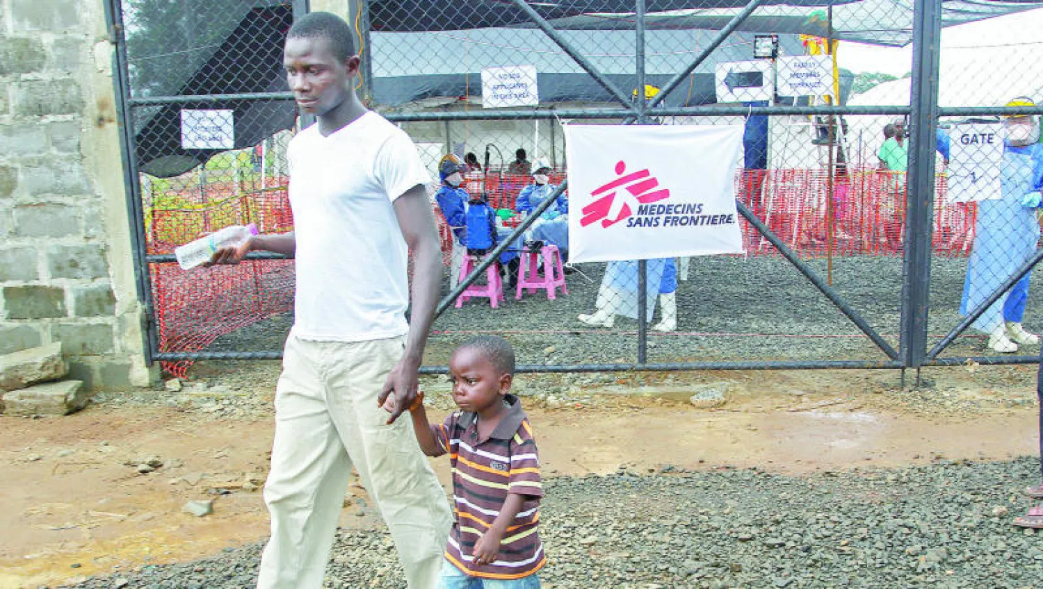 رجل يغادر مركزا صحيا أقامته منظمة «أطباء بلا حدود» قصده بعد ظهور أعراض مرض «إيبولا» لدى ابنه في مونروفيا (إ.ب.أ)