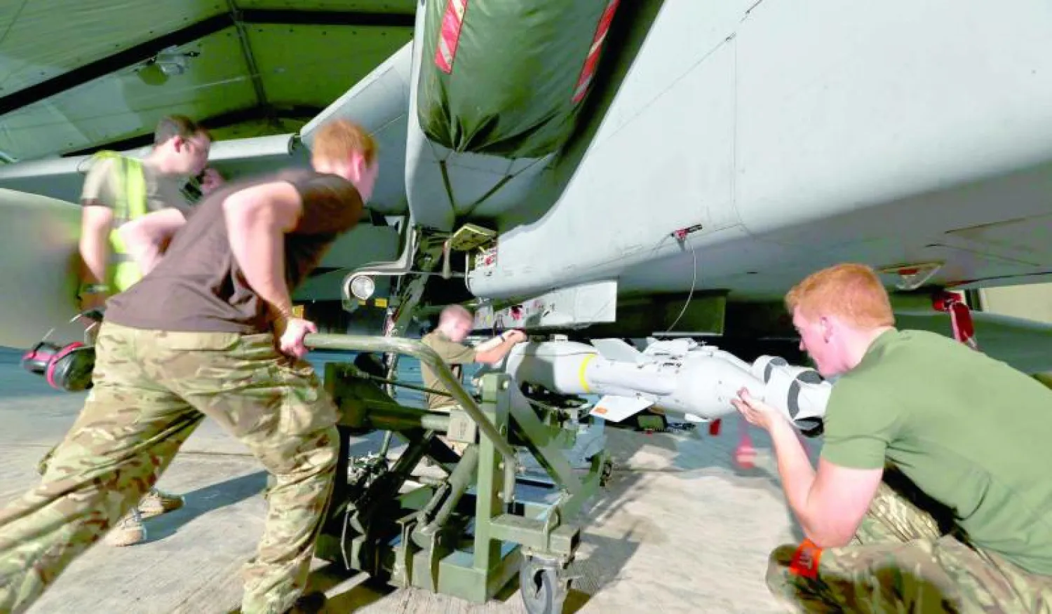 جنود بريطانيون يجهزون طائرة «تورنيدو» قبل إقلاعها من قاعدة جوية في قبرص في طلعة جوية فوق العراق أمس (رويترز)