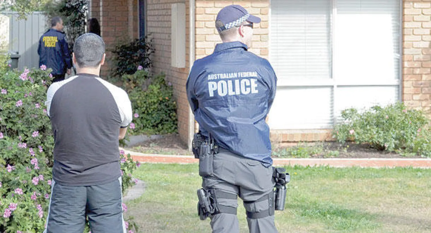 أفراد الشرطة الفيدرالية أمام أحد المنازل التي تمت مداهمتها في ملبورن أمس (إ.ب.أ)