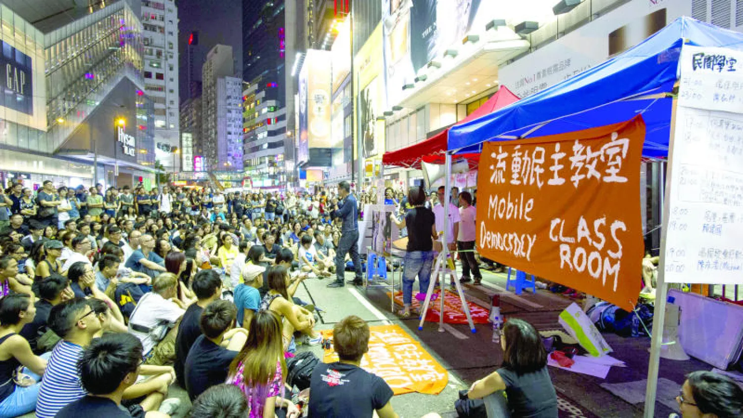 طلاب متظاهرون يحضرون {حصة دراسية} في شارع بهونغ كونغ أمس (ا.ف.ب)