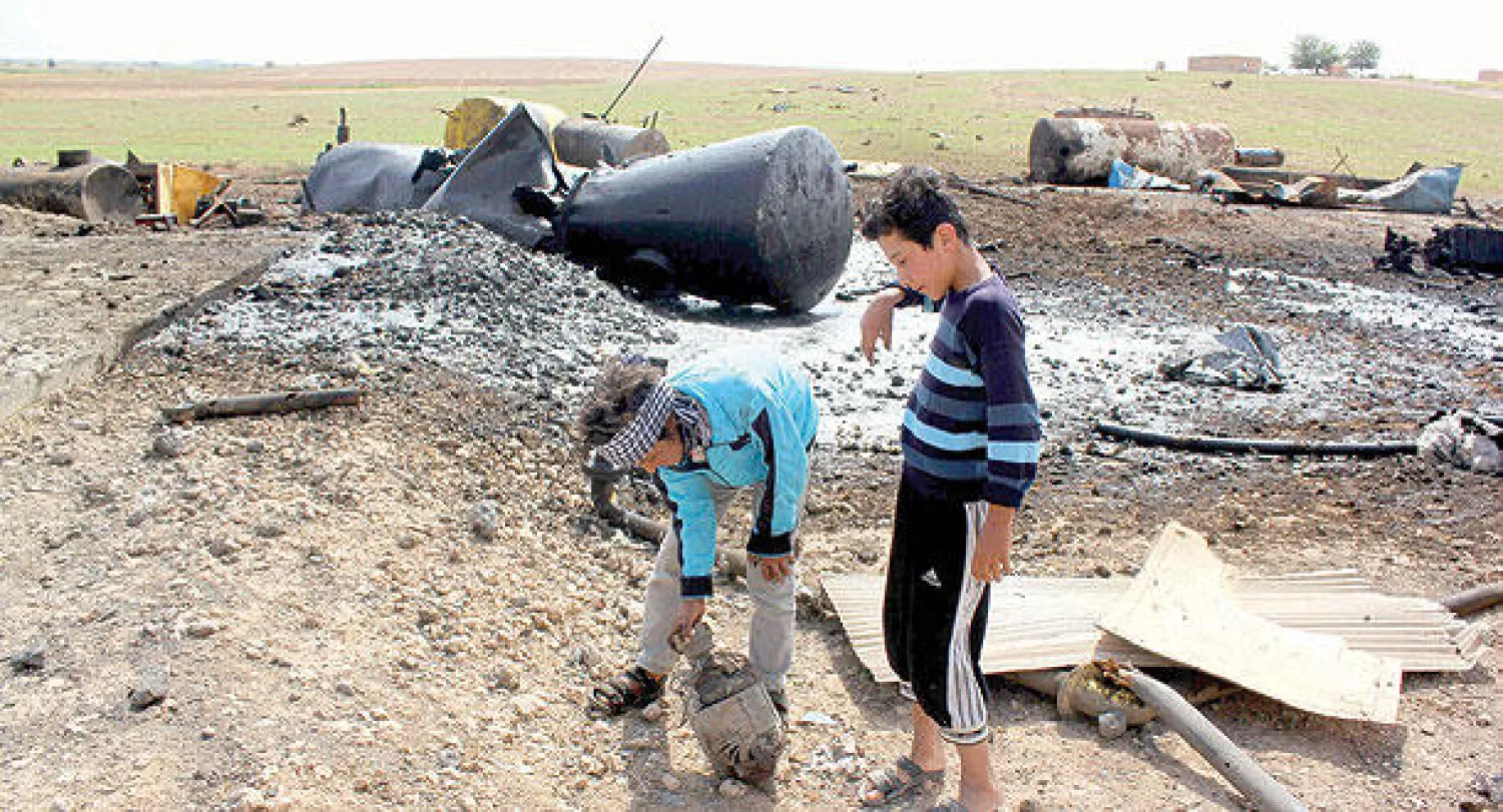 طفلان سوريان يلعبان في منطقة استهدفها طيران الحلفاء ضد «داعش» في المناطق الحدودية بين سوريا وتركيا (أ.ف.ب)