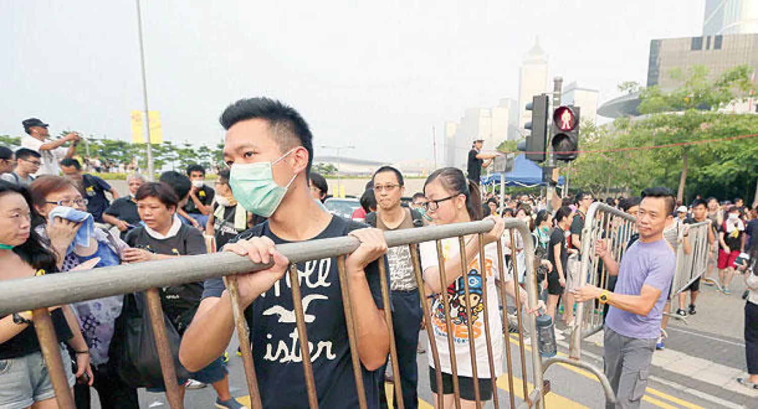 الشرطة تحاول تفريق حشد من الطلاب المتظاهرين  أمام مبنى حكومي في هونغ كونغ أمس (أ.ب)