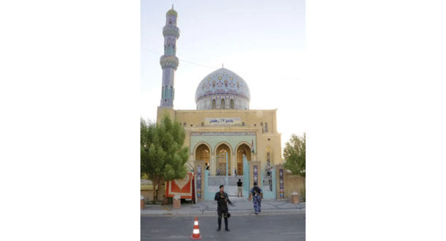 افراد من الشرطة العراقية يحرسون بوابة مسجد 17 رمضان في ساحة الفردوس وسط بغداد خلال صلاة العيد امس(أ ب)