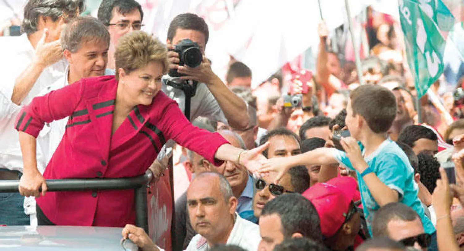 روسيف تمد يدها إلى طفل خلال تجمع انتخابي في ساو خوسيه دوس كامبوس مساء أول من أمس (رويترز)