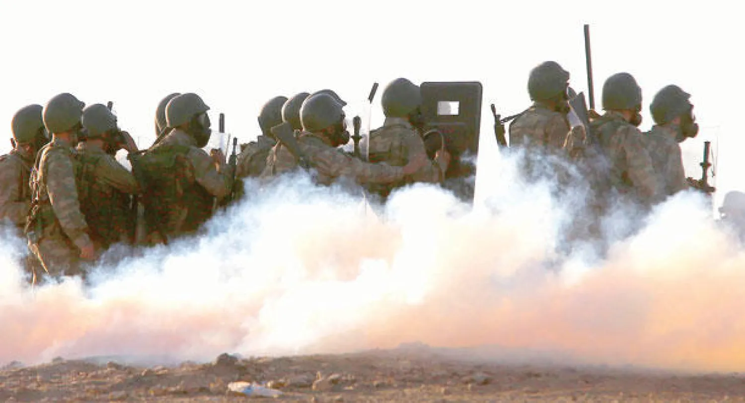 جنود أتراك يستخدمون الغاز المسيل للدموع من أجل تفريق محتجين من أكراد تركيا خرجوا في مظاهرات تضامنية مع أكراد سوريا في منطقة مورسيتبينار الحدودية مع سوريا أمس (رويترز)