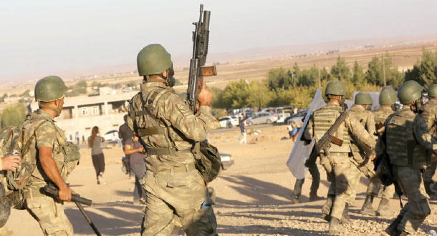 جنود أتراك يتصدون لمحتجين أكراد بالقرب من الحدود السورية أمس حيث تتعرض مدينة كوباني السورية لقصف من عناصر «داعش» (أ.ب)
