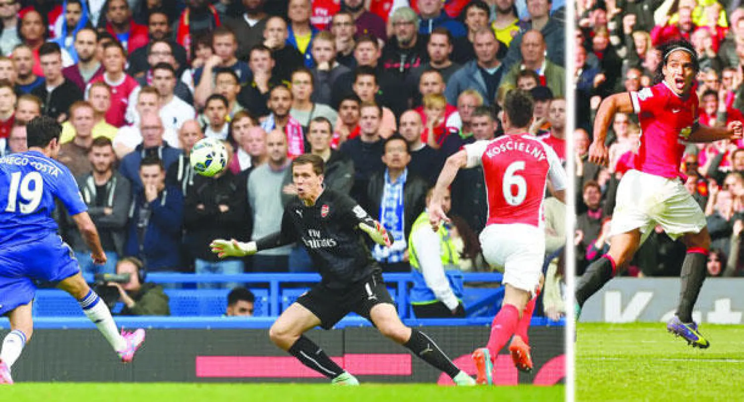 فالكاو يحتفل بهدفه الأول بالدوري الإنجليزي الذي منح يونايتد الفوز (رويترز)  -   كوستا مهاجم تشيلسي المتألق (يسار) يلعب الكرة بمهارة من فوق تشينسي حارس آرسنال ليحرز ثاني أهداف فريقه (إ.ب.أ)