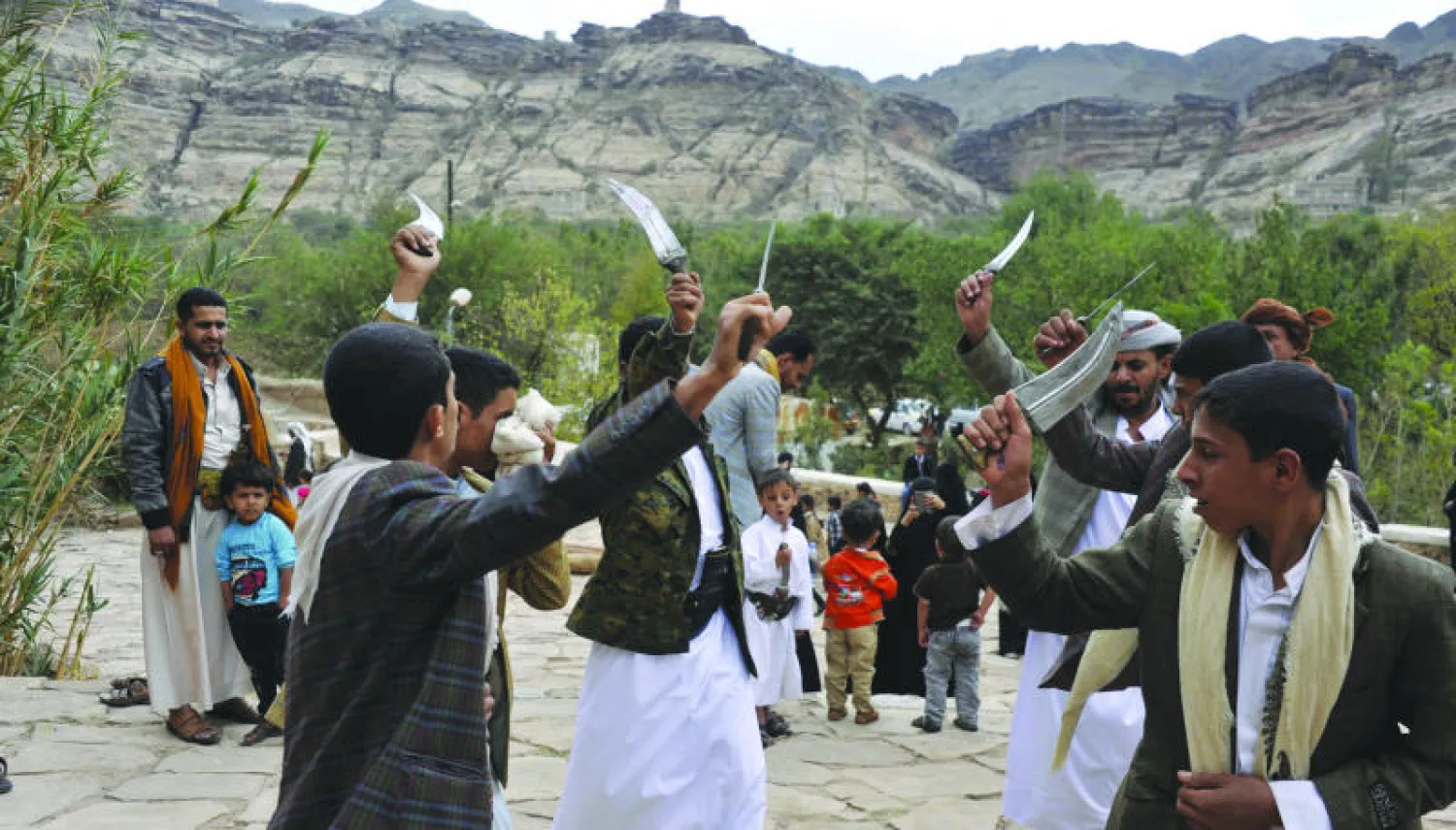 يمنيون يؤدون رقصة فولكلورية برفع الخناجر بمناسبة عيد الأضحى المبارك في واد قريب من العاصمة صنعاء أمس (إ.ب.أ)