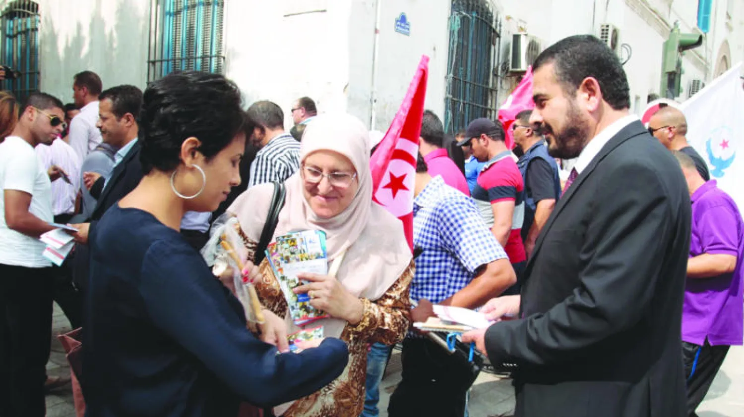 مؤيد لحزب النهضة التونسي يتحدث لامرأة توزع دعايات انتخابية حملة الدعاية التي بدأها الحزب في العاصمة أمس (رويترز)