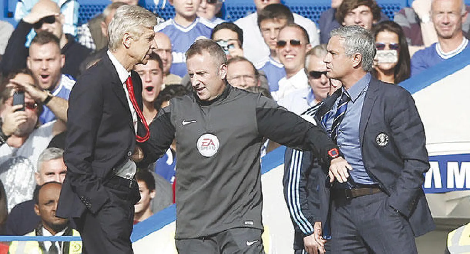 الحكم الرابع يفصل بين مورينهو وأرسين فينغر بعد اشتباكهما بالأيدي (أ.ف.ب)