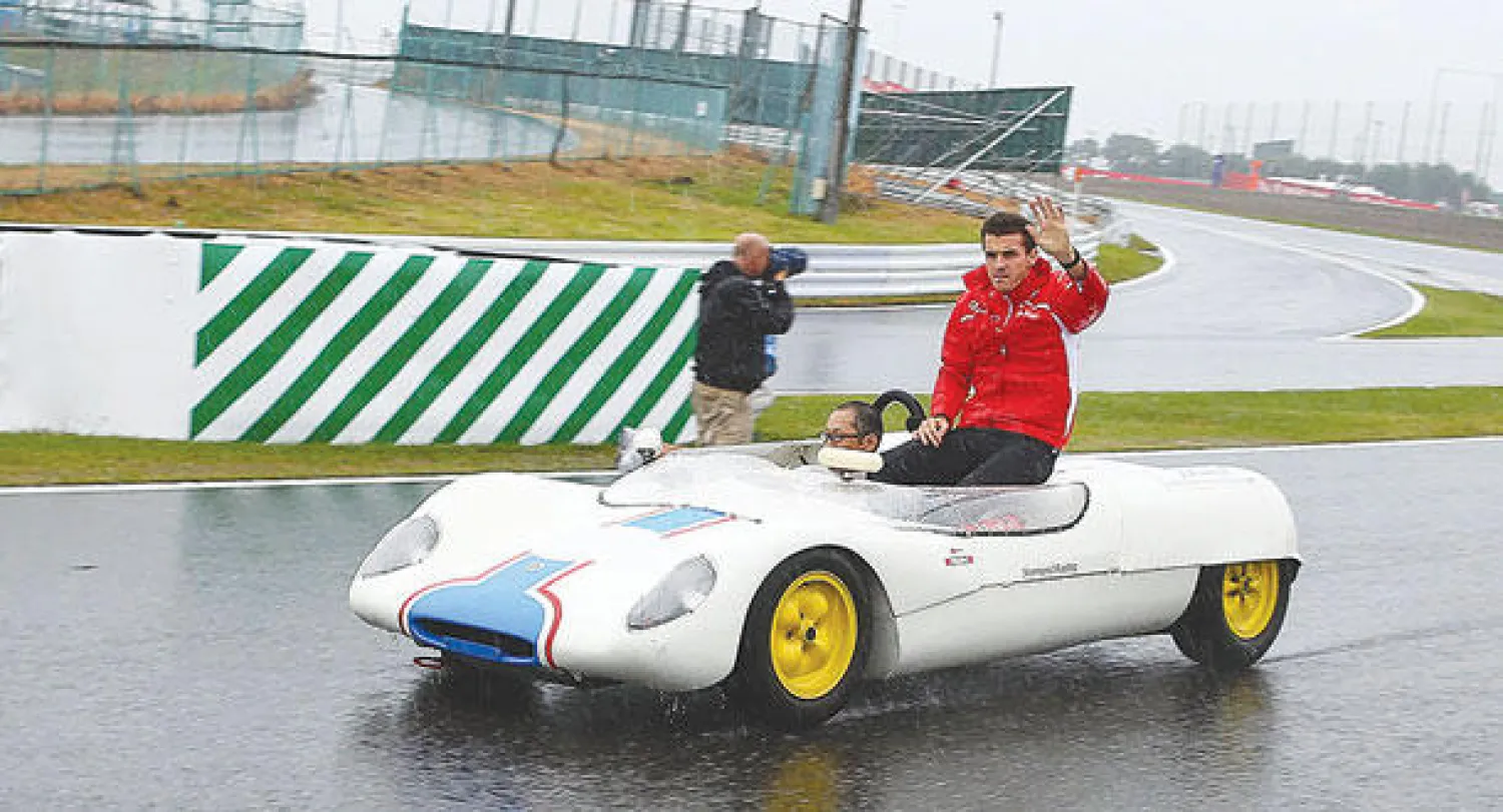 السائق الفرنسي بيانكي يتفقد مضمار اليابان الذي غمرته الأمطار قبل السباق (إ.ب.أ)