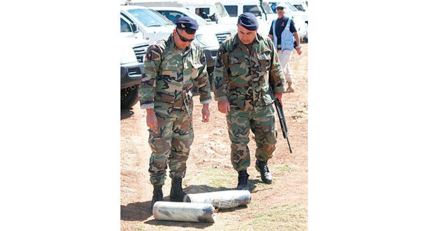 جنود لبنانيون يتفحصون أجزاء من صواريخ  أطلقتها إسرائيل على مزارع شبعا أمس  (رويترز)