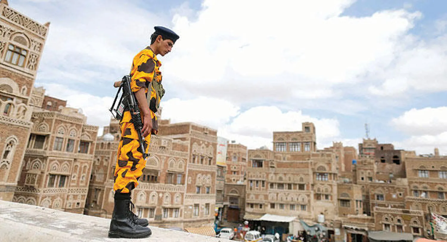 مسلح تابع لجماعة الحوثيين يقوم بالحراسة بزي رجال الشرطة في وسط العاصمة صنعاء أمس (رويترز)