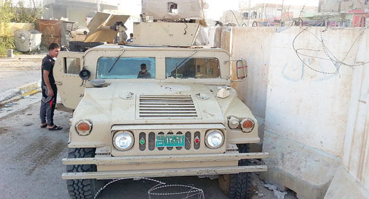 شاب عراقي يتفحص عربة مدرعة تركها الجيش العراقي في هيت قرب الأنبار «داعش» (رويترز)