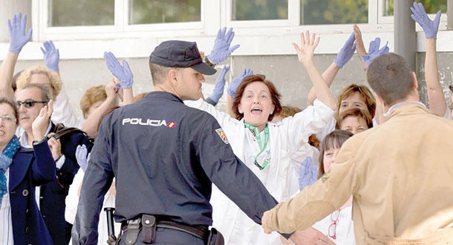 عاملون في القطاع الطبي بمدريد يحتجون على رئيس الوزراء الإسباني راخوي أثناء زيارته لمستشفى كارلوس الثالث أمس (أ.ب)