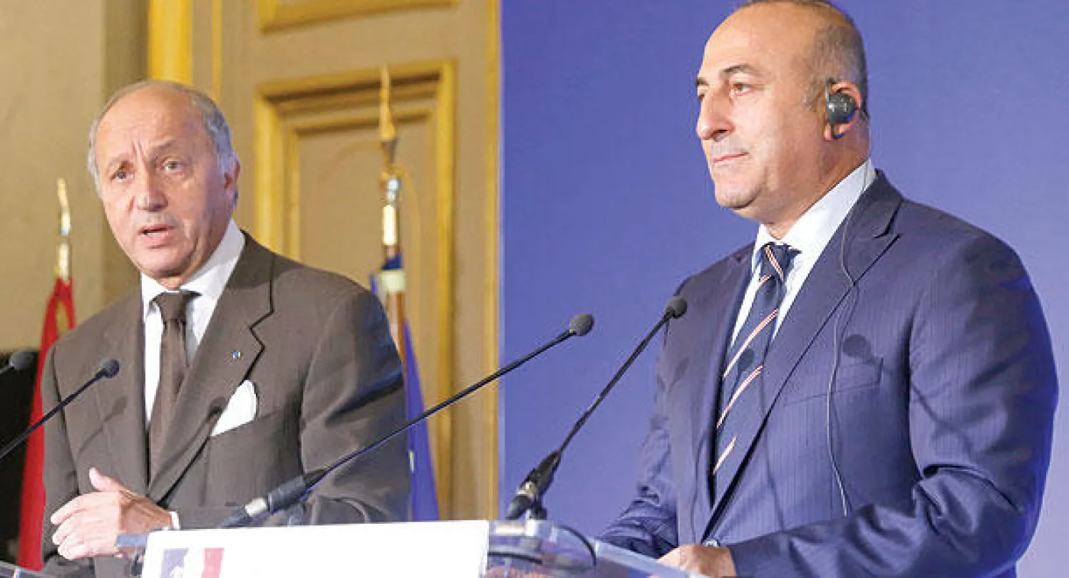 وزيرا خارجية فرنسا لوران فابيوس وتركيا مولود جاويش أوغلو  يجيبان عن أسئلة الصحافيين في باريس أمس (أ.ف.ب)