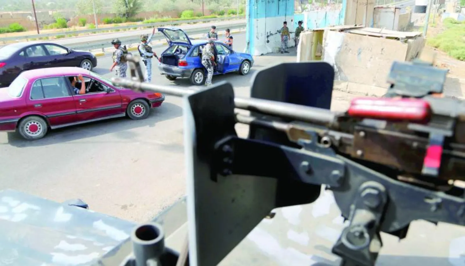 عناصر في الشرطة العراقية يفتشون سيارة عند نقطة تفتيش في بغداد أمس (أ.ب)