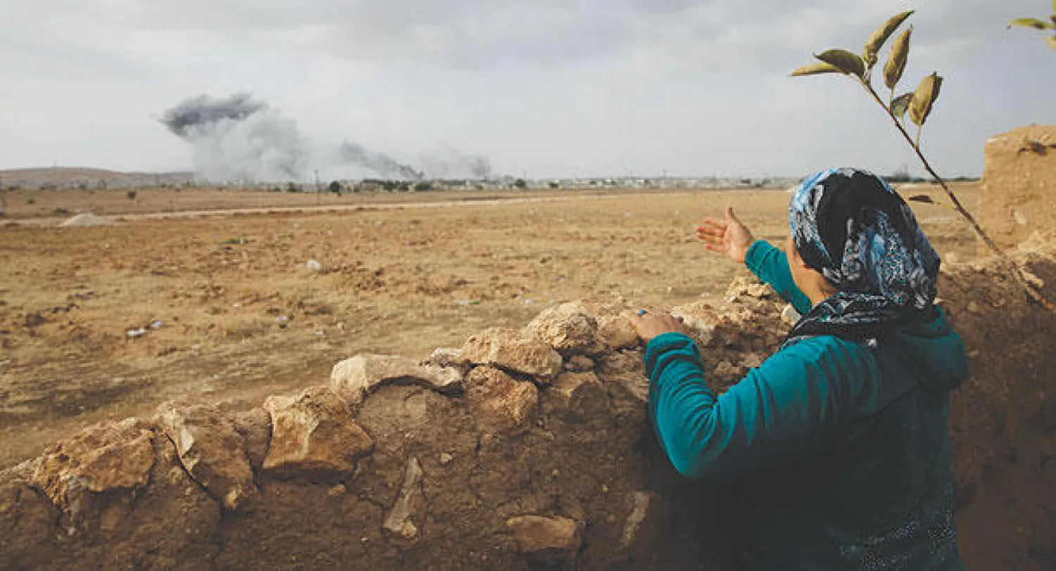 امرأة من أكراد تركيا تتابع عبر الحدود المعارك الدائرة في كوباني (أ.ب)