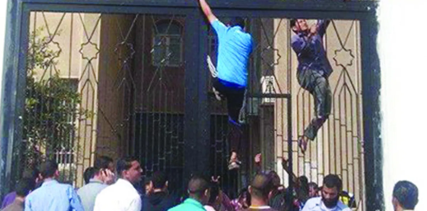 طلاب يتسلقون أبواب جامعة الأزهر هربا من الزحام الذي سببته الإجراءات الأمنية المشددة على المداخل الرئيسية