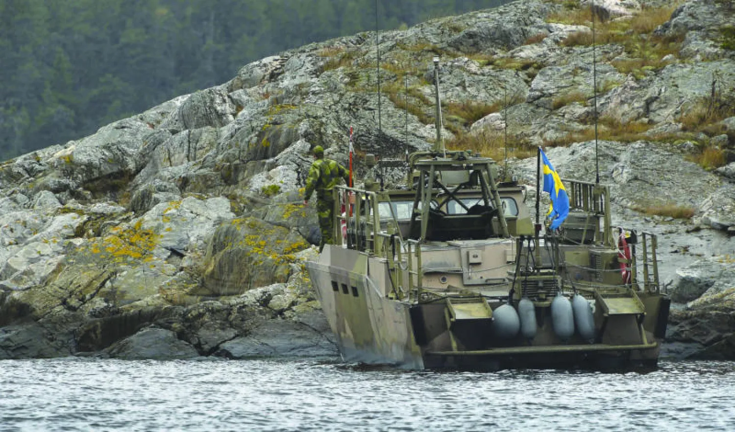 قارب سويدي يشارك في البحث عن الغواصة الغامضة قرب جزيرة كولبالينغ القريبة من العاصمة السويدية أمس (أ.ف.ب)