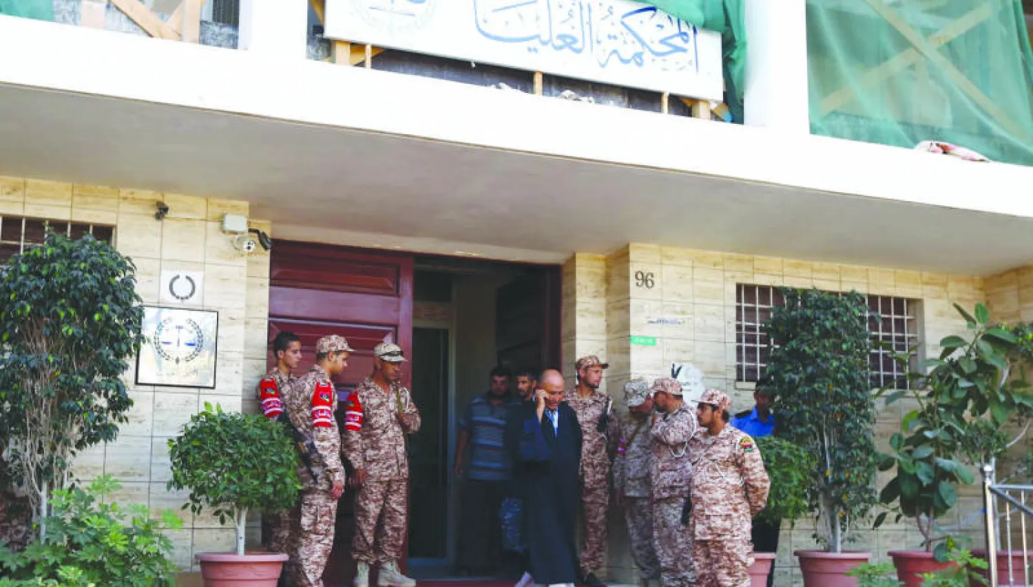 عناصر من قوات الأمن الليبية يحرسون مدخل المحكمة العليا في العاصمة الليبية طرابلس أمس بعد بدء المحكمة النظر في الطعون في دستورية الاجتماعات والقرارات الصادرة عن البرلمان (أ.ف.ب)