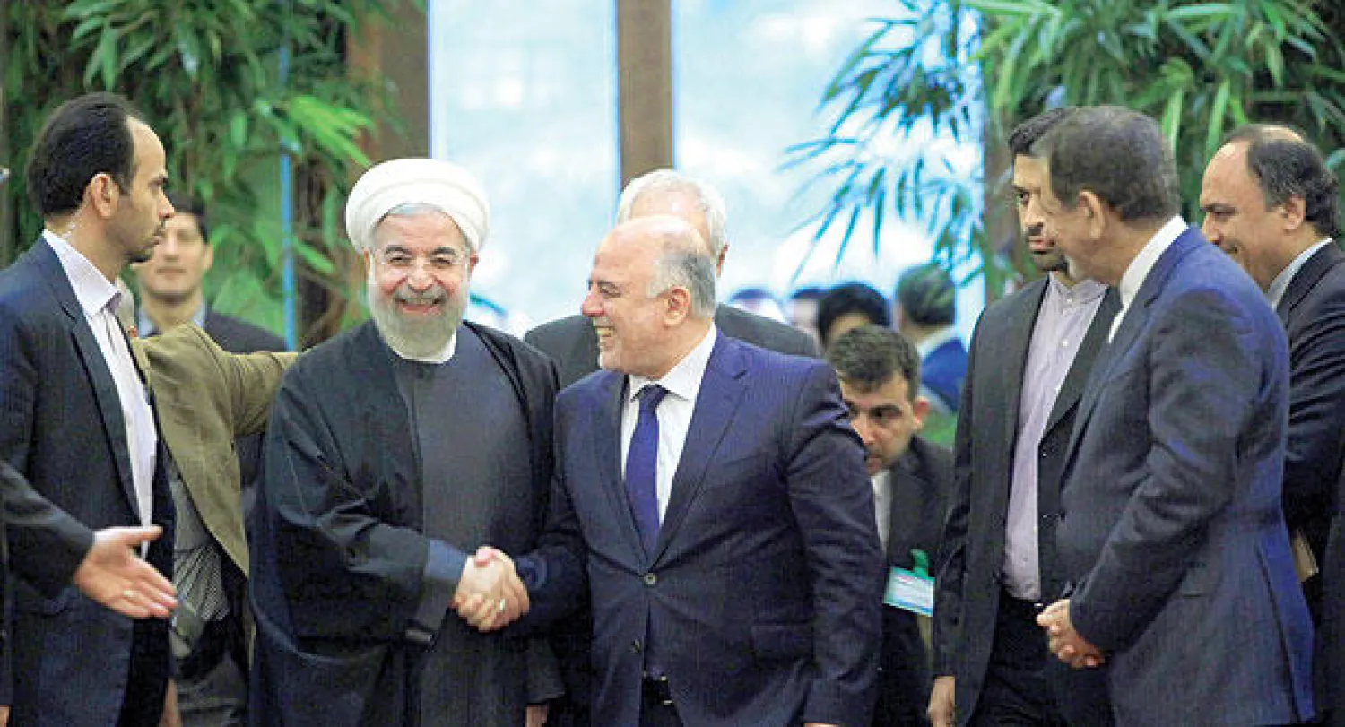 الرئيس الإيراني حسن روحاني لدى استقباله في طهران أمس رئيس الوزراء العراقي حيدر العبادي (أ.ب)