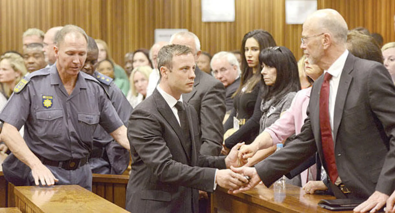 أوسكار بيستوريوس يسلم عمه ساعته بعد صدور الحكم وقبل توجهه إلى السجن (أ.ب)