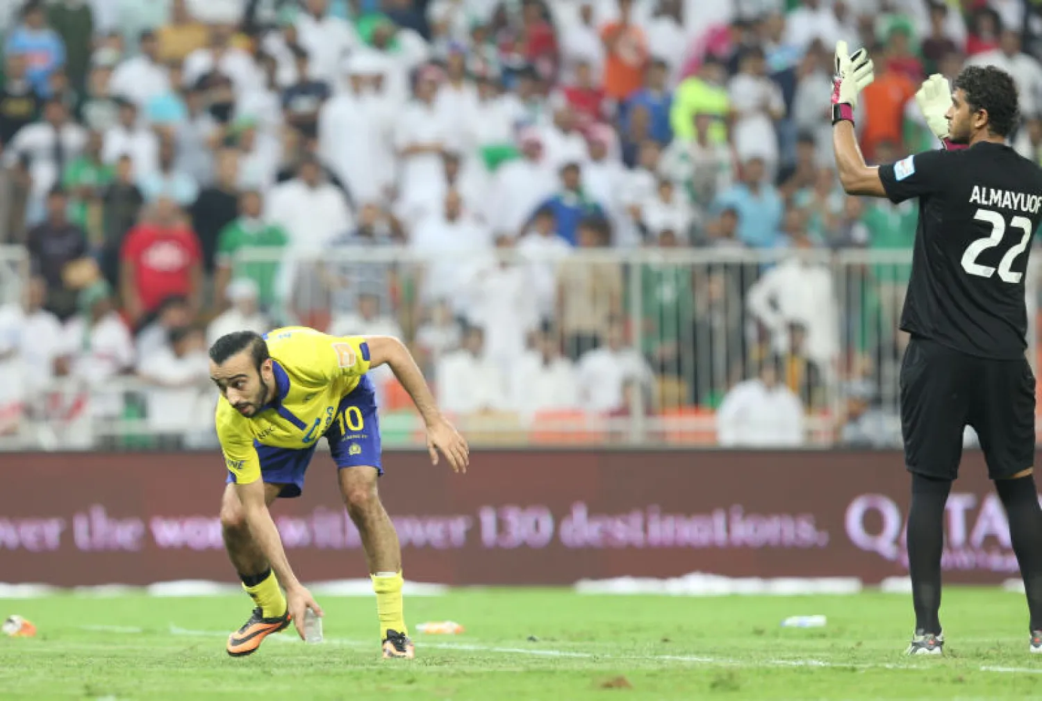 محمد السهلاوي يبعد الفوارغ التي قذفت بها جماهير النصر حارس الأهلي عبد الله معيوف (تصوير: عدنان مهدلي)