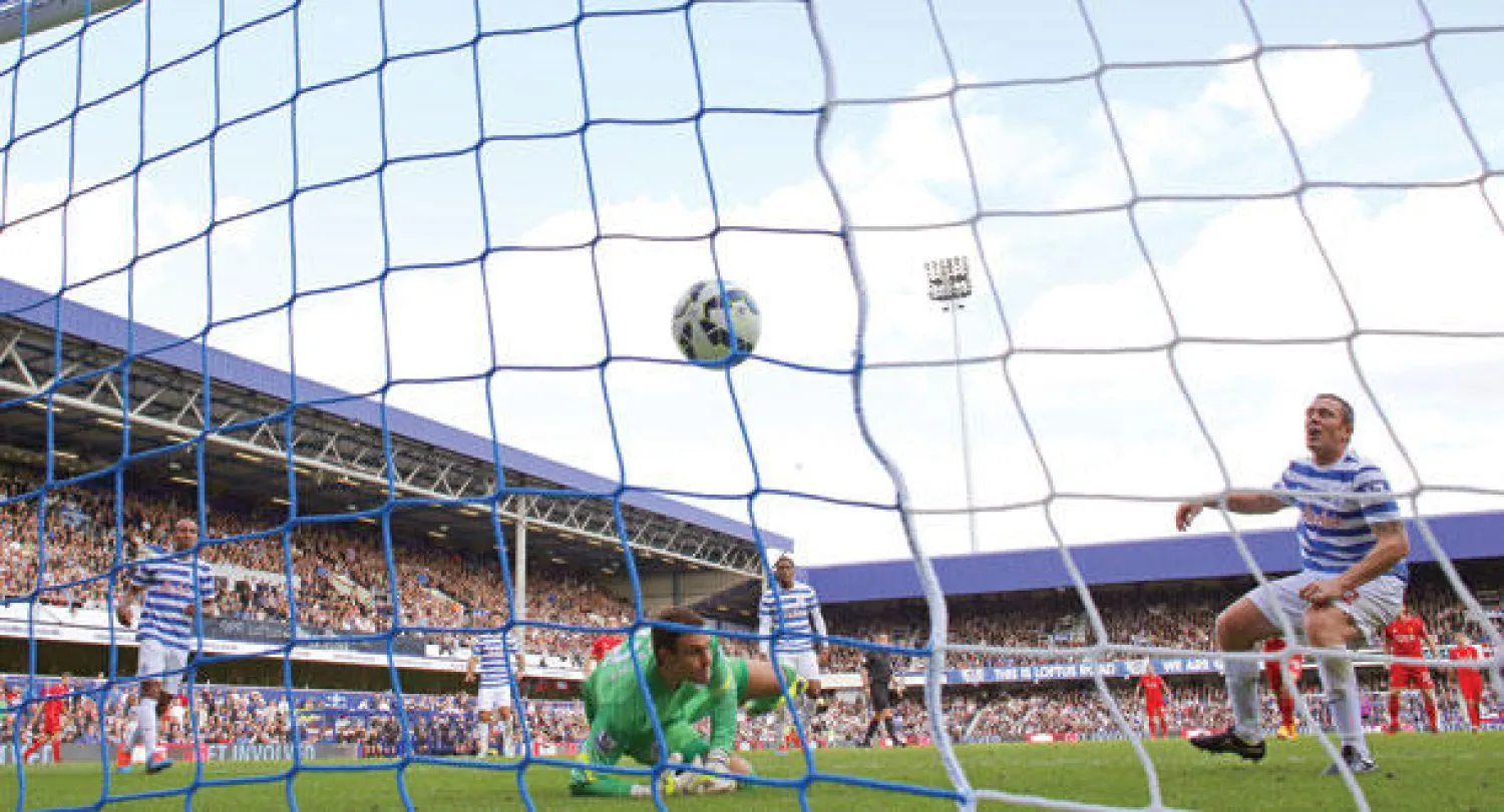 ريتشارد دان (يمين) يسكن الكرة شباك مرمى فريقه كوينز بارك بالخطأ أمام ليفربول في دلالة على ضعف الدفاع (أ.ف.ب)