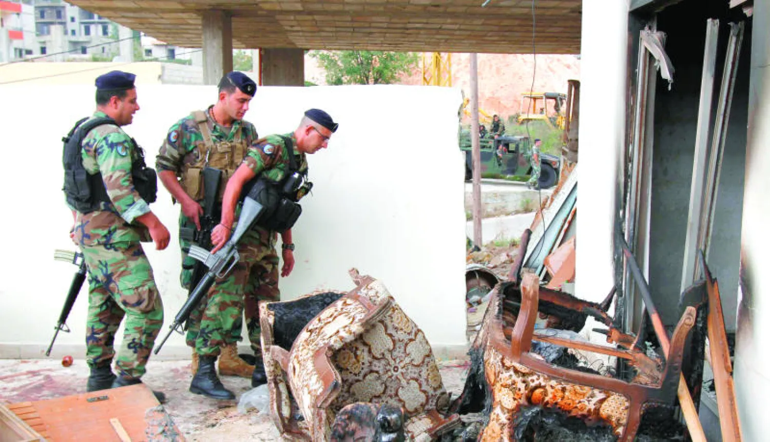 جنود لبنانيون أمام الشقة التي اقتحمها الجيش أمس حيث قتل 3 أشخاص من المتحصنين داخلها وأوقف آخرين شمال مدينة عاصون  في لبنان (رويترز)