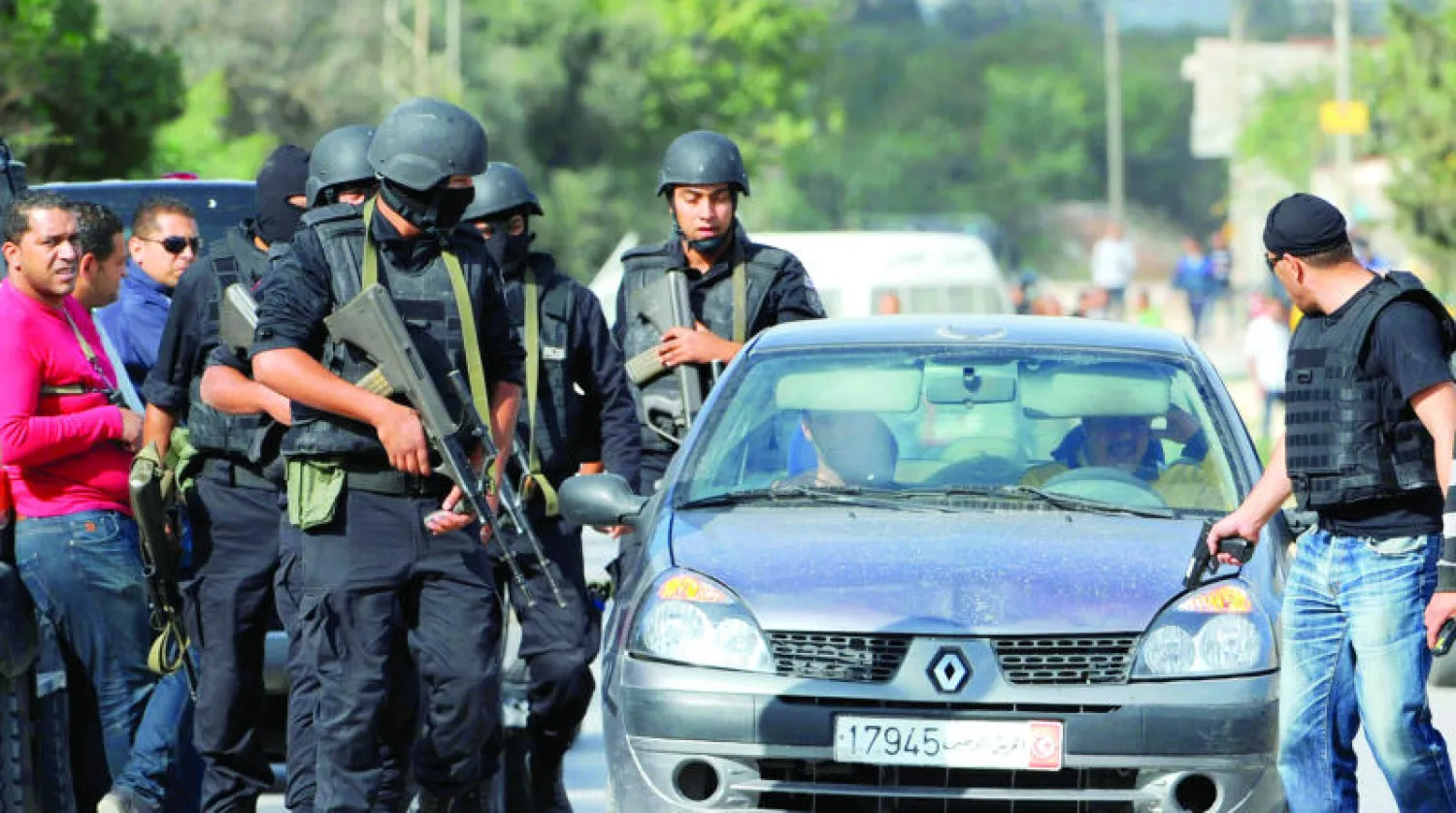 عناصر من الجيش التونسي في نقطة تفتيش بالقرب من منزل تحصن فيه إرهابيون أمس بمنطقة واد الليل غرب تونس العاصمة أمس (أ.ف.ب)