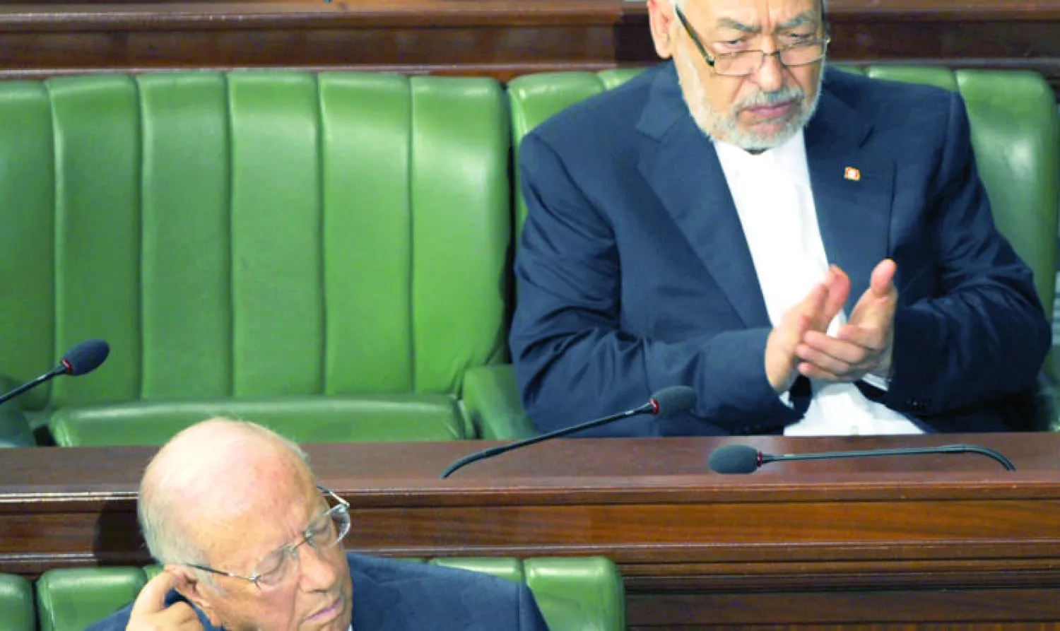 صورة أرشيفية لراشد الغنوشي زعيم حركة النهضة (يمين الصورة) ورئيس حزب «نداء تونس» الباجي قائد السبسي في المجلس التأسيسي (البرلمان) التونسي (أ.ف.ب)