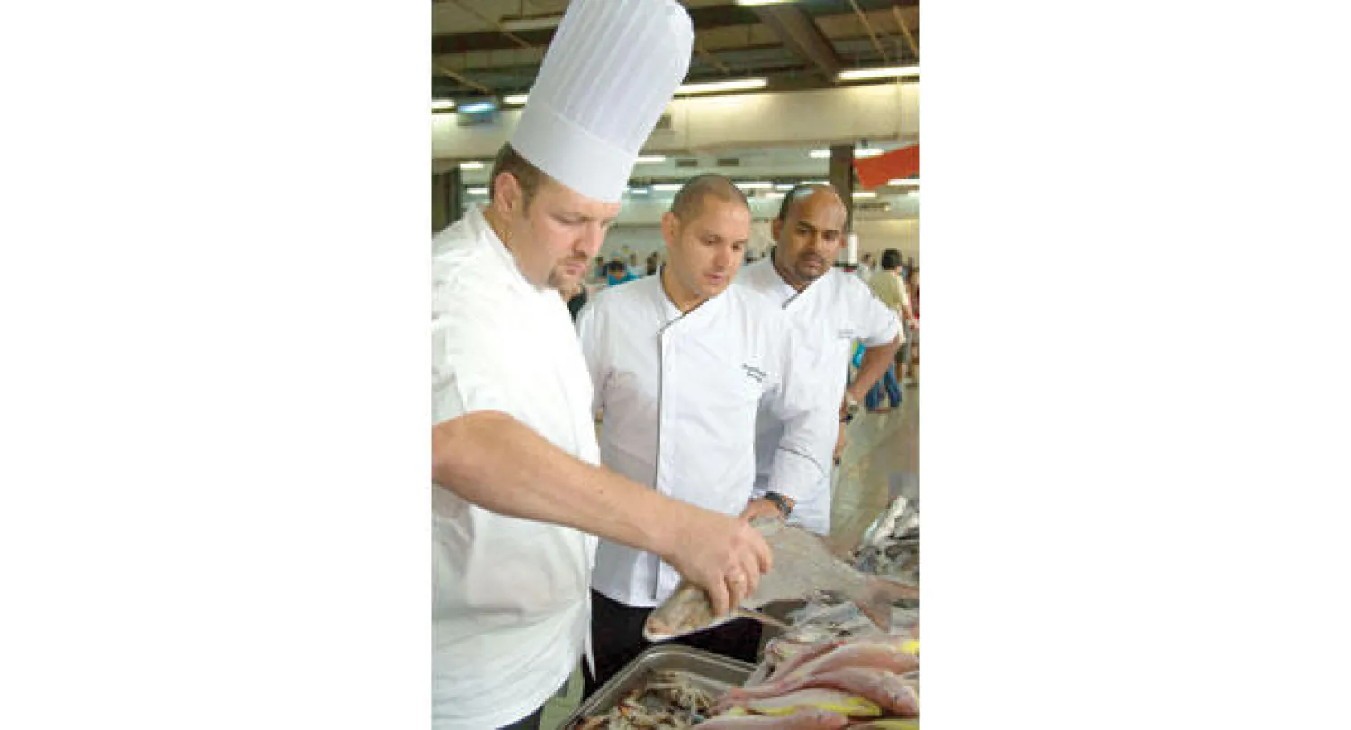 يقوم الطاهي في مطعم «الصياد» باختيار الأسماك بتأن