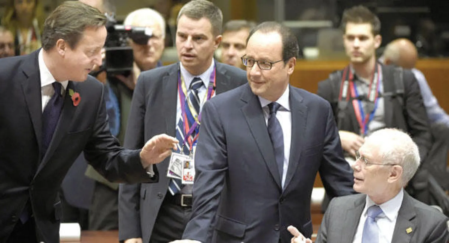 رئيس الوزراء البريطاني ديفيد كاميرون (يسار) يتحدث مع الرئيس الفرنسي فرانسوا هولاند ورئيس المجلي الأوروبي غان رومبوي أمس (أ. ف. ب)