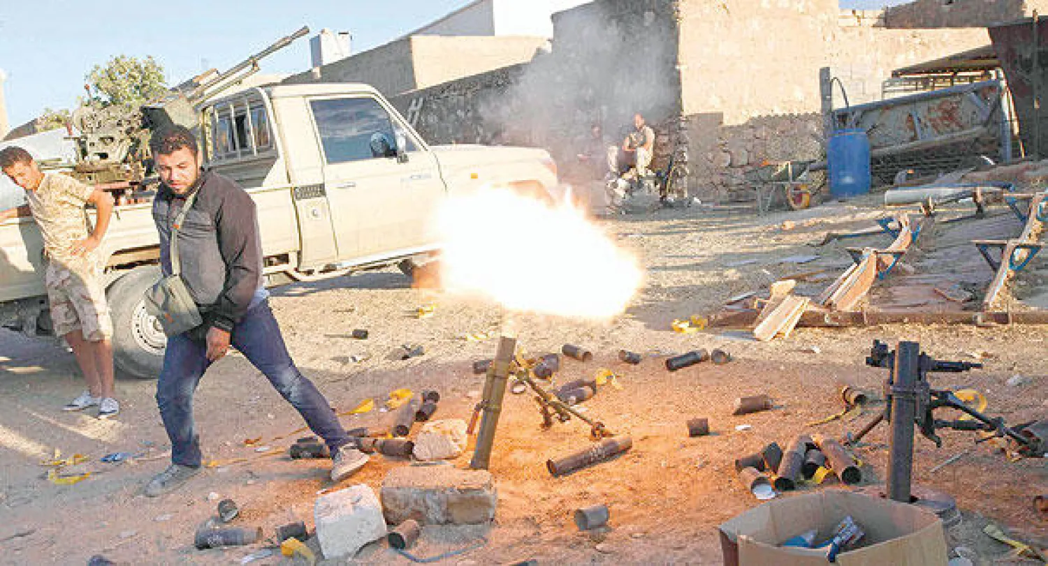 عنصر تابع لمجموعة {عملية الفجر} يطلق قذيفة مورتر أثناء المواجهات مع جماعة {كتيبة الزنتان} جنوب غربي العاصمة طرابلس (رويترز)