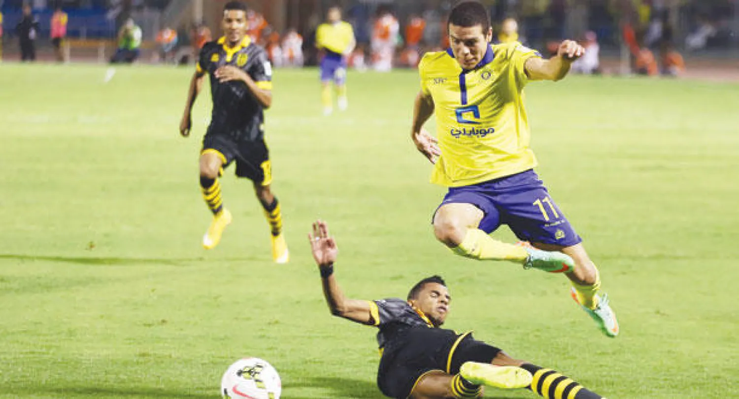 ماركينيوس لاعب النصر يتخطى مدافع الاتحاد عسيري في مواجهة الفريقين أول من أمس (تصوير: عبد العزيز النومان)
