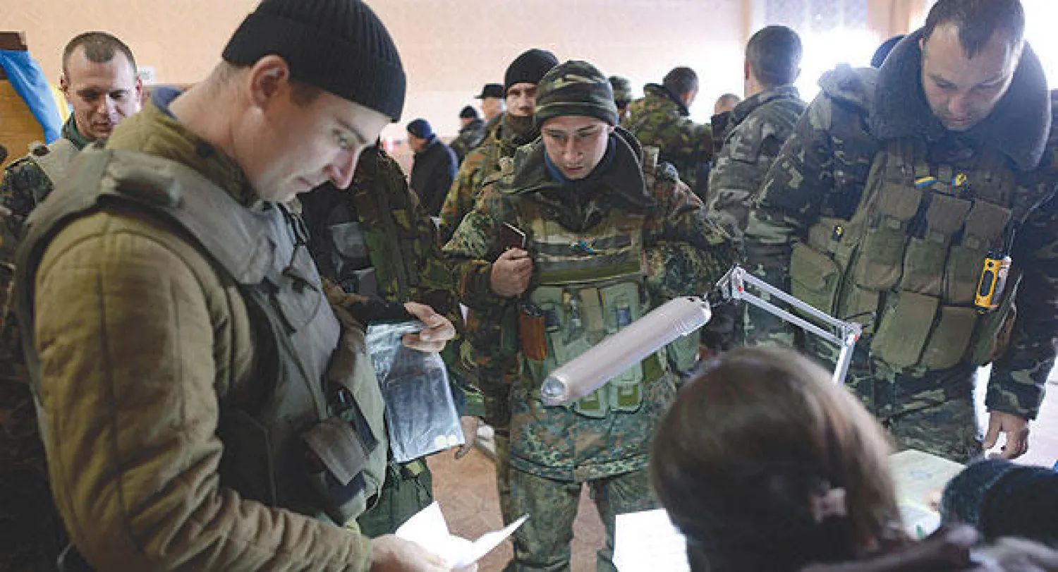 قوات أمن أوكرانية تشارك في عملية التصويت في لوهانسك أمس (رويترز)