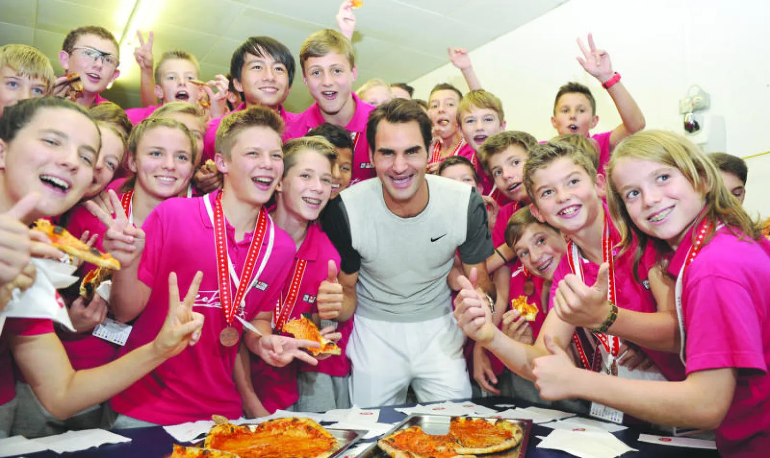 فيدرر شارك أطفال الملعب أكل البيتزا بعد فوزه ببطولة بازل (أ.ف.ب)